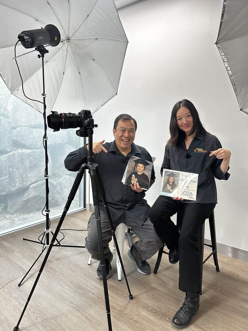 Hetty and David in their studio, holding graduation keepsakes